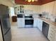 Kitchen features white cabinets, stainless steel appliances, and tile floors at 2428 Columbia Dr # 72, Clearwater, FL 33763