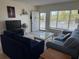 Bright living room featuring plush seating, large windows, and a view from the doorway to the outside balcony at 2428 Columbia Dr # 72, Clearwater, FL 33763