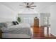 Bright bedroom featuring tray ceiling, ceiling fan, and hardwood flooring at 27524 Pine Point Dr, Wesley Chapel, FL 33544