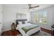 This bedroom features a ceiling fan, a large window, and wood floors at 27524 Pine Point Dr, Wesley Chapel, FL 33544