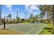 Community basketball court surrounded by lush landscaping and a pond, providing recreation and natural beauty at 310 Cockle Shell Loop, Apollo Beach, FL 33572