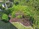 A manicured garden bed with colorful flowers surrounded by mature trees and lush greenery at 3267 Westcott Ct, Palm Harbor, FL 34684