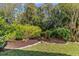 Landscaped backyard with a neatly mulched garden and lush lawn creating a serene outdoor space at 3267 Westcott Ct, Palm Harbor, FL 34684