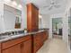 Well-lit bathroom featuring dual vanities, granite countertops, wood cabinets and access to the main bedroom at 3267 Westcott Ct, Palm Harbor, FL 34684