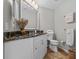Well-lit bathroom featuring granite countertop, white cabinetry, and decorative accents at 3267 Westcott Ct, Palm Harbor, FL 34684