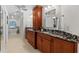 Spacious bathroom with dual sinks, dark wood cabinets and granite countertops at 3267 Westcott Ct, Palm Harbor, FL 34684