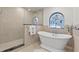 Luxurious bathroom showcasing a glass-enclosed shower, freestanding tub, and a unique stained-glass window at 3267 Westcott Ct, Palm Harbor, FL 34684