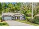 Charming single-story home with well-manicured lawn, mature trees, and a two-car garage at 3267 Westcott Ct, Palm Harbor, FL 34684