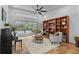 Cozy living room with travertine floors, built-in shelving, neutral furniture, and view of screened pool at 3267 Westcott Ct, Palm Harbor, FL 34684