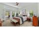 A bright and airy main bedroom with neutral tones, a ceiling fan, and access to the screened lanai at 3267 Westcott Ct, Palm Harbor, FL 34684