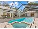 This backyard features a pool, spa, outdoor seating, and kitchen, perfect for entertaining at 3267 Westcott Ct, Palm Harbor, FL 34684