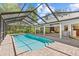 The screen enclosed pool has a spa and brick surround with access to the home's interior at 3267 Westcott Ct, Palm Harbor, FL 34684