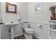 Bright and airy powder room with pedestal sink, toilet, and decorative accents at 3267 Westcott Ct, Palm Harbor, FL 34684