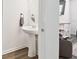 Stylish half bathroom featuring a pedestal sink, a round mirror, and tile flooring at 4326 Banjo Lake Rd, Land O Lakes, FL 34639