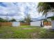 Home's exterior showing grass area, fencing, storage building, and seating area at 4601 71St N Ave, Pinellas Park, FL 33781