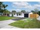 Charming single-story home with a well-manicured lawn, blacktop driveway, and a freshly painted white exterior at 4601 71St N Ave, Pinellas Park, FL 33781