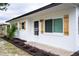 Exterior view of a well-maintained home with a white exterior, shuttered windows, and a nicely landscaped front yard at 4601 71St N Ave, Pinellas Park, FL 33781