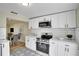 Updated kitchen with sleek appliances, white cabinets, and black and white patterned floor open to the dining room at 4601 71St N Ave, Pinellas Park, FL 33781