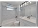 Clean bathroom with white marble subway tile, white fixtures, and a shower-tub combination at 513 E Langford Dr, Plant City, FL 33563