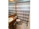 Bathroom with marble floors, wood vanity, and a gray and white striped shower curtain at 520 Oak Creek Dr, Brandon, FL 33511