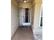 Covered entryway with a brown door, tiled floor, and a white metal security door at 520 Oak Creek Dr, Brandon, FL 33511