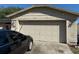 Attached two car garage in a single story home with a dark colored sedan in the driveway at 520 Oak Creek Dr, Brandon, FL 33511