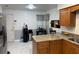 Open kitchen with stainless steel appliances, island with granite countertops, and white tile flooring at 520 Oak Creek Dr, Brandon, FL 33511