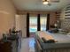 Bright main bedroom featuring a ceiling fan, white-tile floors, and backyard pool view at 520 Oak Creek Dr, Brandon, FL 33511