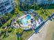 Aerial view of complex pool with lush landscaping, a sunny deck and nearby beach access at 5701 Bahia Del Mar Cir # 408, St Petersburg, FL 33715
