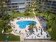 Aerial view of complex pool with lush landscaping, a sunny deck and nearby beach access at 5701 Bahia Del Mar Cir # 408, St Petersburg, FL 33715