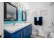 Nautical-themed bathroom features a double vanity with blue cabinetry and stylish decor for a beach-inspired aesthetic at 5701 Bahia Del Mar Cir # 408, St Petersburg, FL 33715