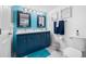 Bathroom featuring double vanity with blue cabinets and coastal decor at 5701 Bahia Del Mar Cir # 408, St Petersburg, FL 33715