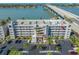 Exterior of condo building shows balconies, spiral stairs, parking and a unit location via a red arrow at 5701 Bahia Del Mar Cir # 408, St Petersburg, FL 33715
