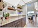 Stylish bar featuring dark wood cabinets, granite counters and natural lighting at 6324 Brevada Ln, Apollo Beach, FL 33572
