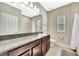 Neutral bathroom featuring a shower-tub combo, granite countertops, wood cabinets, and tile flooring at 6324 Brevada Ln, Apollo Beach, FL 33572