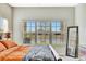 Bedroom with a king-size bed, large window with blinds, and wooden dresser at 6324 Brevada Ln, Apollo Beach, FL 33572