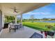 Covered patio overlooking a lush green lawn, beautiful pond, and landscaping at 6324 Brevada Ln, Apollo Beach, FL 33572