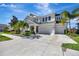 Lovely two-story home boasts a three-car garage, manicured lawn, and beautiful palm trees at 6324 Brevada Ln, Apollo Beach, FL 33572
