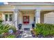 Inviting front porch featuring stately columns and an elegant red front door at 6324 Brevada Ln, Apollo Beach, FL 33572