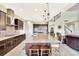 Open kitchen with large granite island, dark wood cabinets, stainless steel appliances and stylish pendant lighting at 6324 Brevada Ln, Apollo Beach, FL 33572