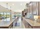 Spacious kitchen featuring long island with sink, granite counters, stainless appliances, and dark wood cabinets at 6324 Brevada Ln, Apollo Beach, FL 33572