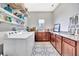 Laundry room featuring decorative floors, modern appliances, and overhead shelving at 6324 Brevada Ln, Apollo Beach, FL 33572