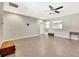 Open living room area with tile floor, neutral paint, baseboards, ceiling fan and two storage chests at 6324 Brevada Ln, Apollo Beach, FL 33572