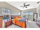 Bright main bedroom featuring large windows, a ceiling fan and stylish wooden furniture at 6324 Brevada Ln, Apollo Beach, FL 33572