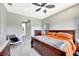 Bright main bedroom featuring carpet floors, ceiling fan and a wooden bed at 6324 Brevada Ln, Apollo Beach, FL 33572