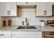 Close-up shot of a kitchen sink featuring granite countertops, white cabinets, and a stylish faucet at 6680 67Th N Way, Pinellas Park, FL 33781