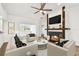 Bright living room featuring a fireplace with a mantle and TV, ceiling fan and white walls at 6680 67Th N Way, Pinellas Park, FL 33781