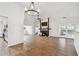 Open floor plan featuring hardwood floors, modern chandelier, fireplace, white walls and open kitchen at 6680 67Th N Way, Pinellas Park, FL 33781