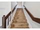 Staircase with wood stairs and brown railing, leading to an upper level at 6680 67Th N Way, Pinellas Park, FL 33781