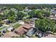 Aerial view showcasing the property's pool area, backyard, and surrounding neighborhood with mature trees at 8210 Marigold Ave, Tampa, FL 33614